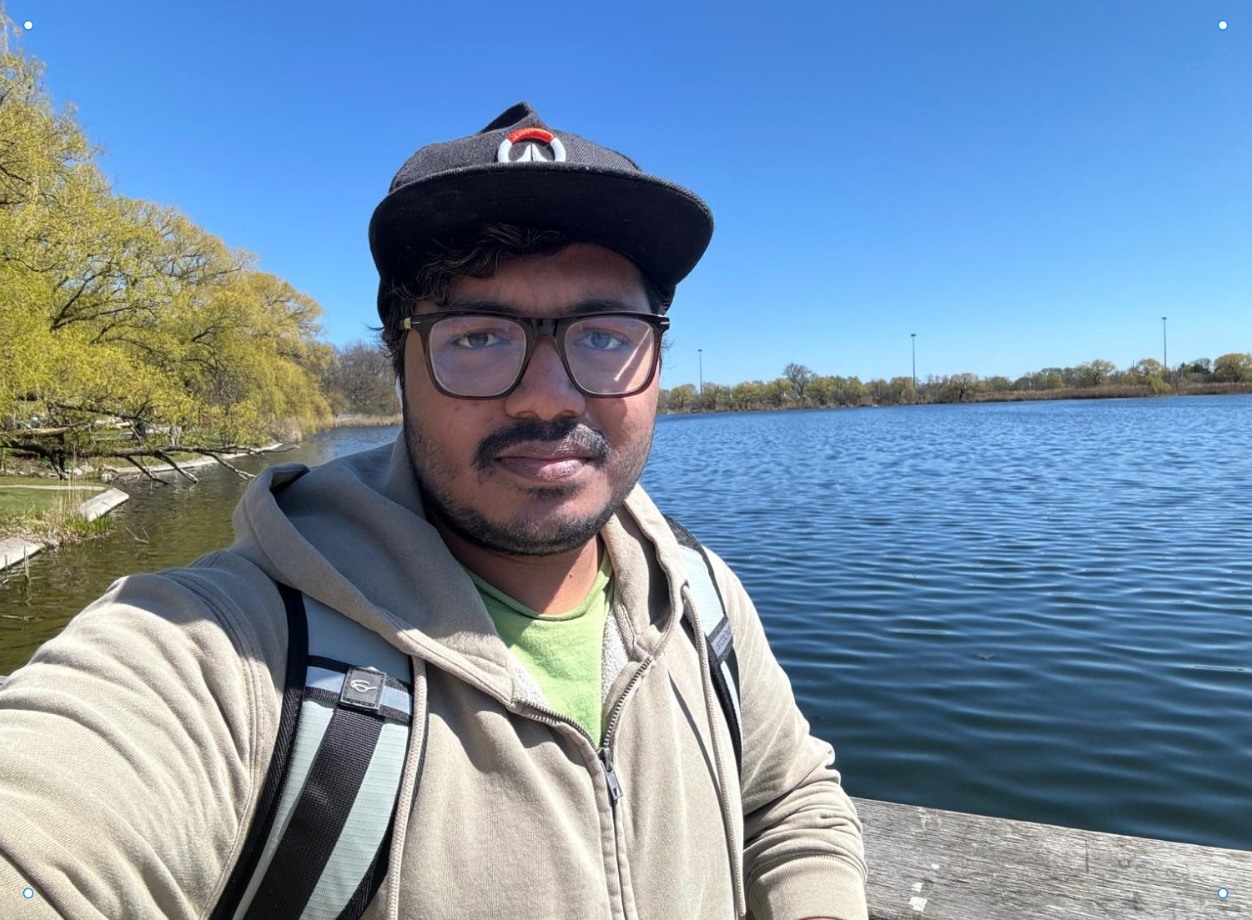Noibedya standing by a lake on a sunny day